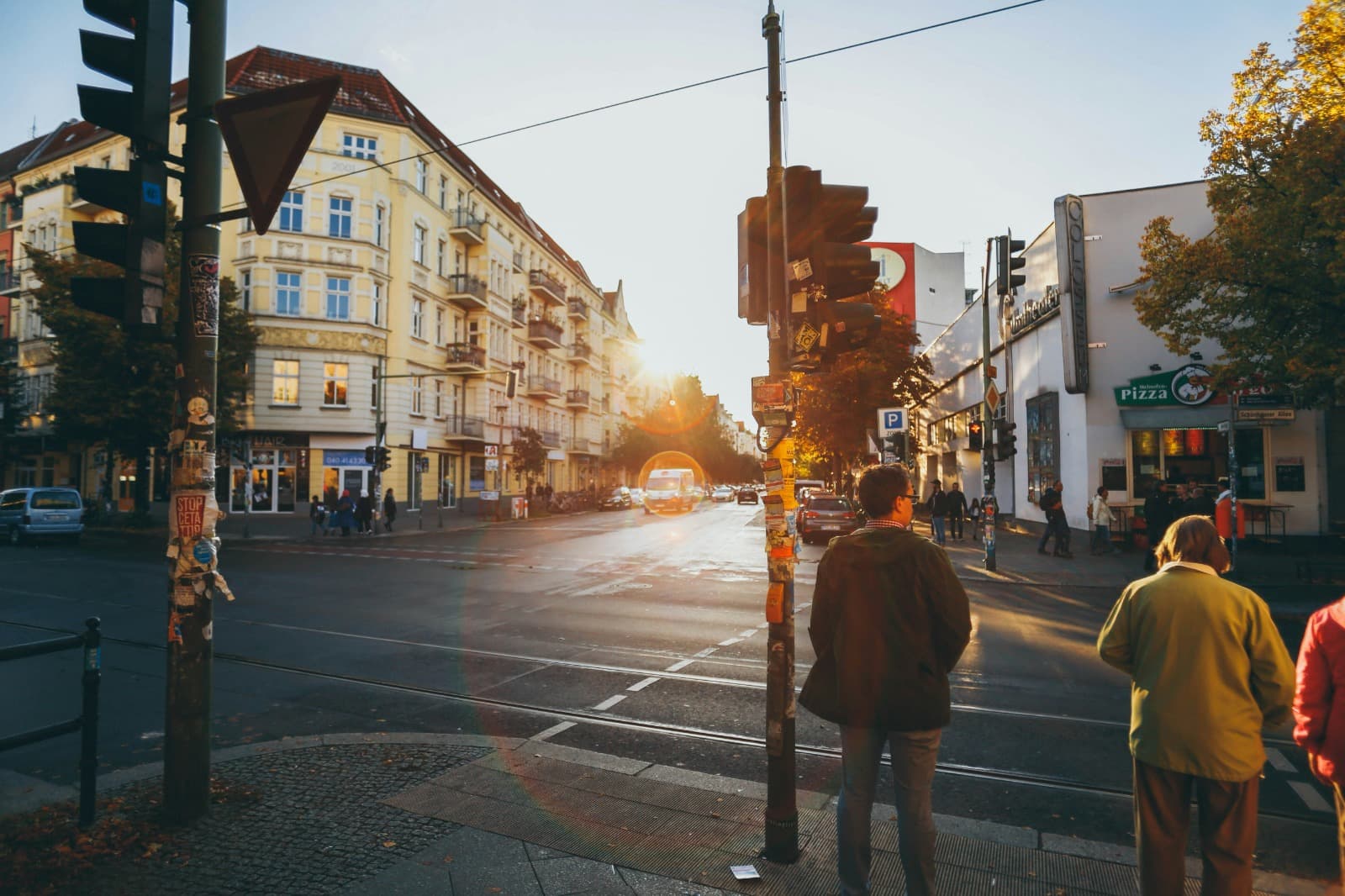 Berlin street at golden hour with trams, crosswalks, and warm sunlight